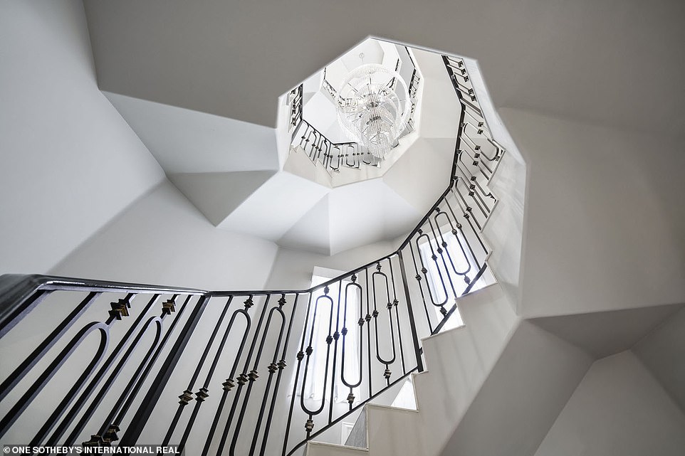 It almost makes you feel dizzy: A look at the spiraled rod-iron staircase from the first floor; notice the chandelier